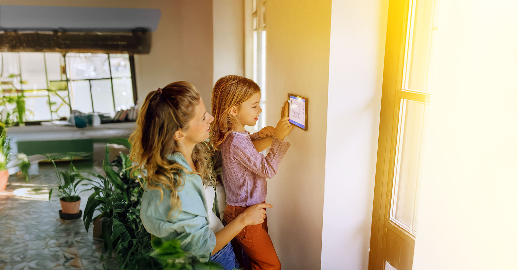 Mama mit Kind regelt die smarte Heizung