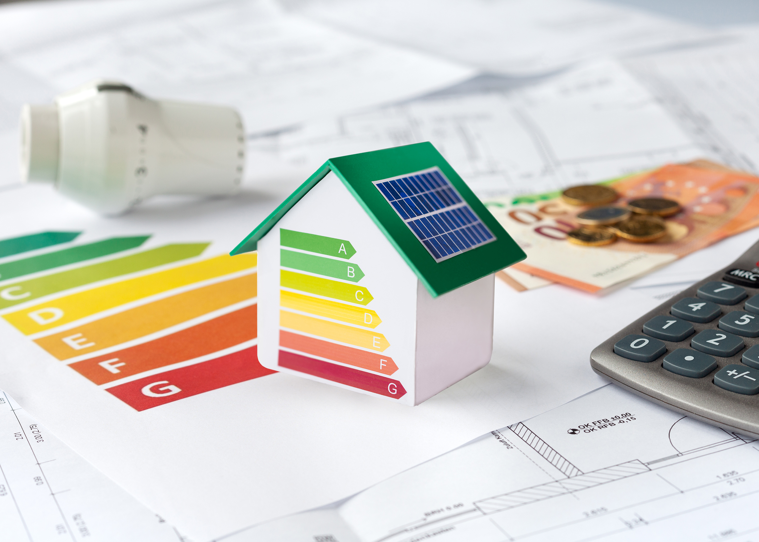 Energieberatung mit Bauplänen, Rechner, Geld und Thermostat - Beantragung von Fördermitteln zur energetischen Sanierung einer Immobilie