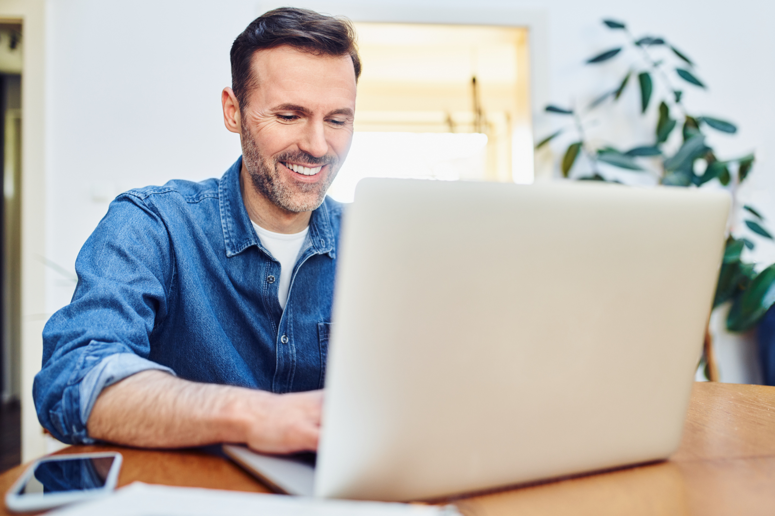 Mann sitzt vor dem Laptop und arbeitet