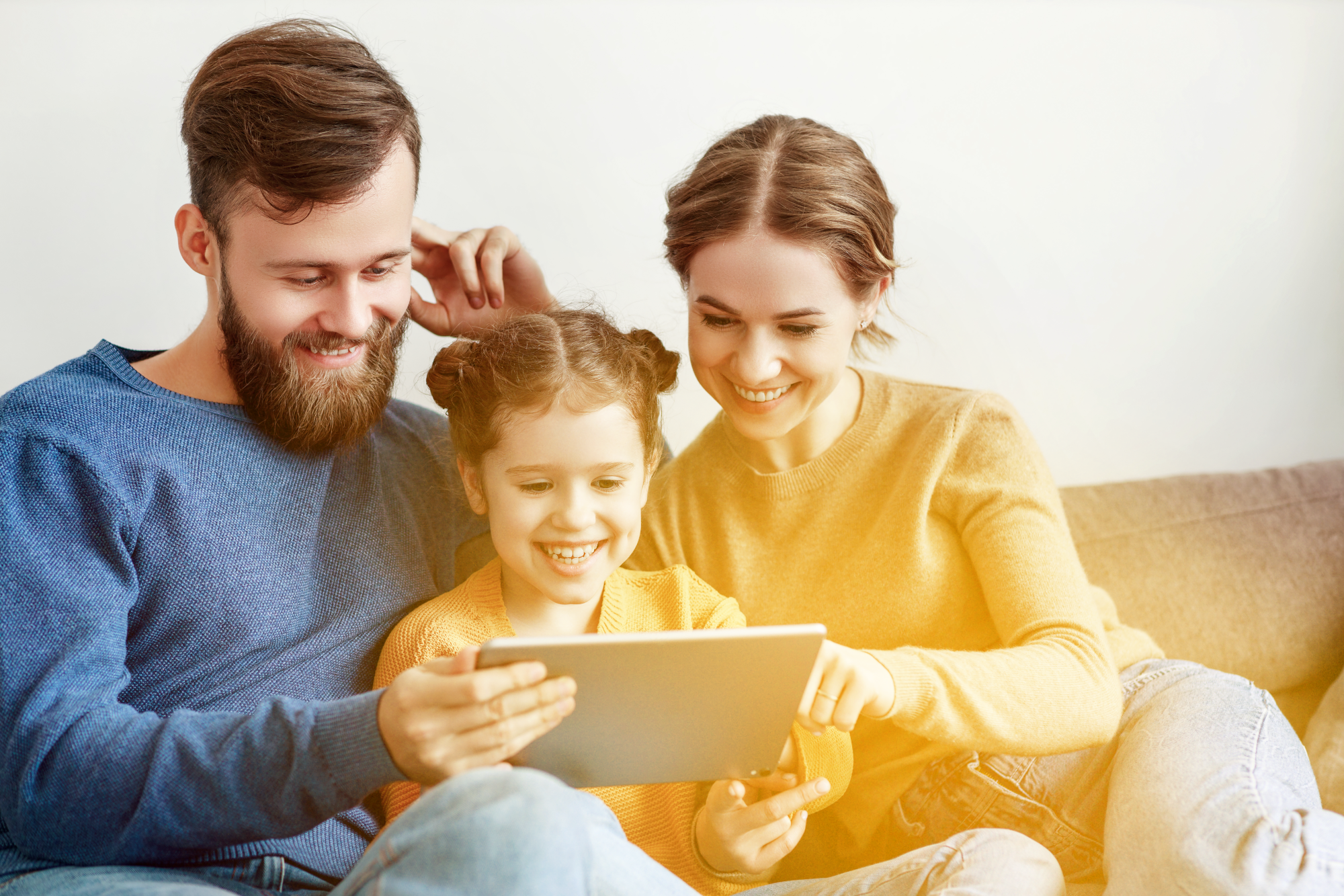 Eine Familie sitzt vorm Fernseher und isst Popcorn.