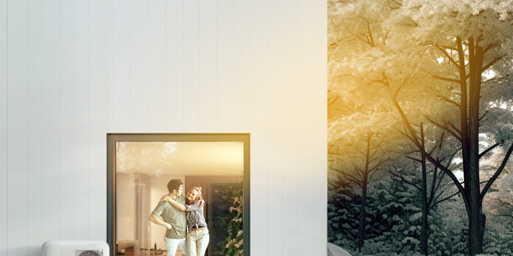 Pärchen steht im Haus. Im Vordergrund befindet sich eine Wärmepumpe