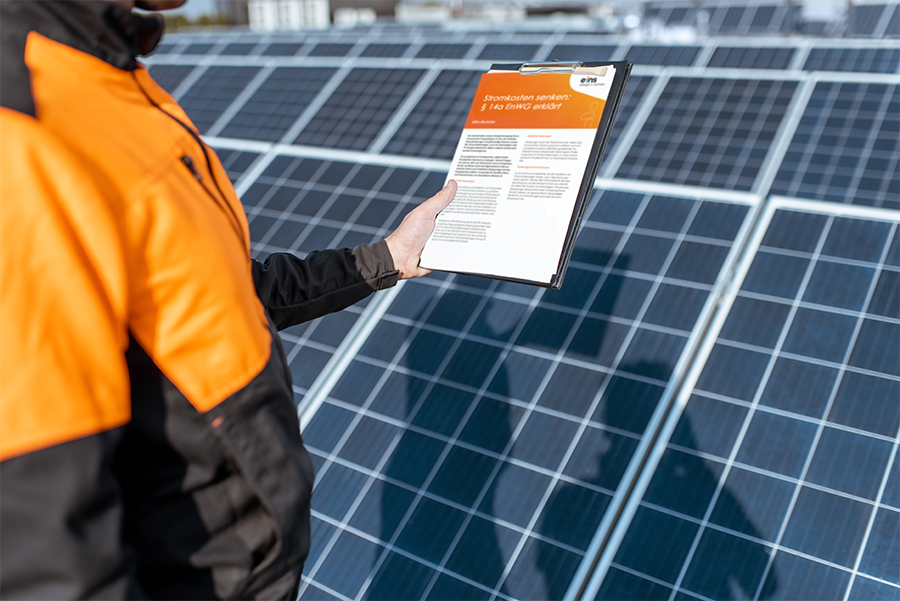 Mann vor Solaranlage hält ein Schreiben des Energiewirtschaftsgesetzes Paragraph 14a hoch