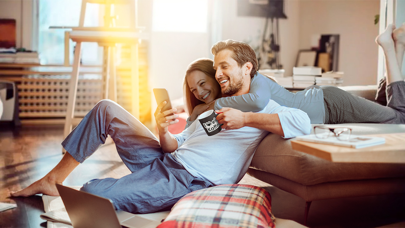 Mann und Frau liegen auf der Couch und schauen sich den eins-Blog an