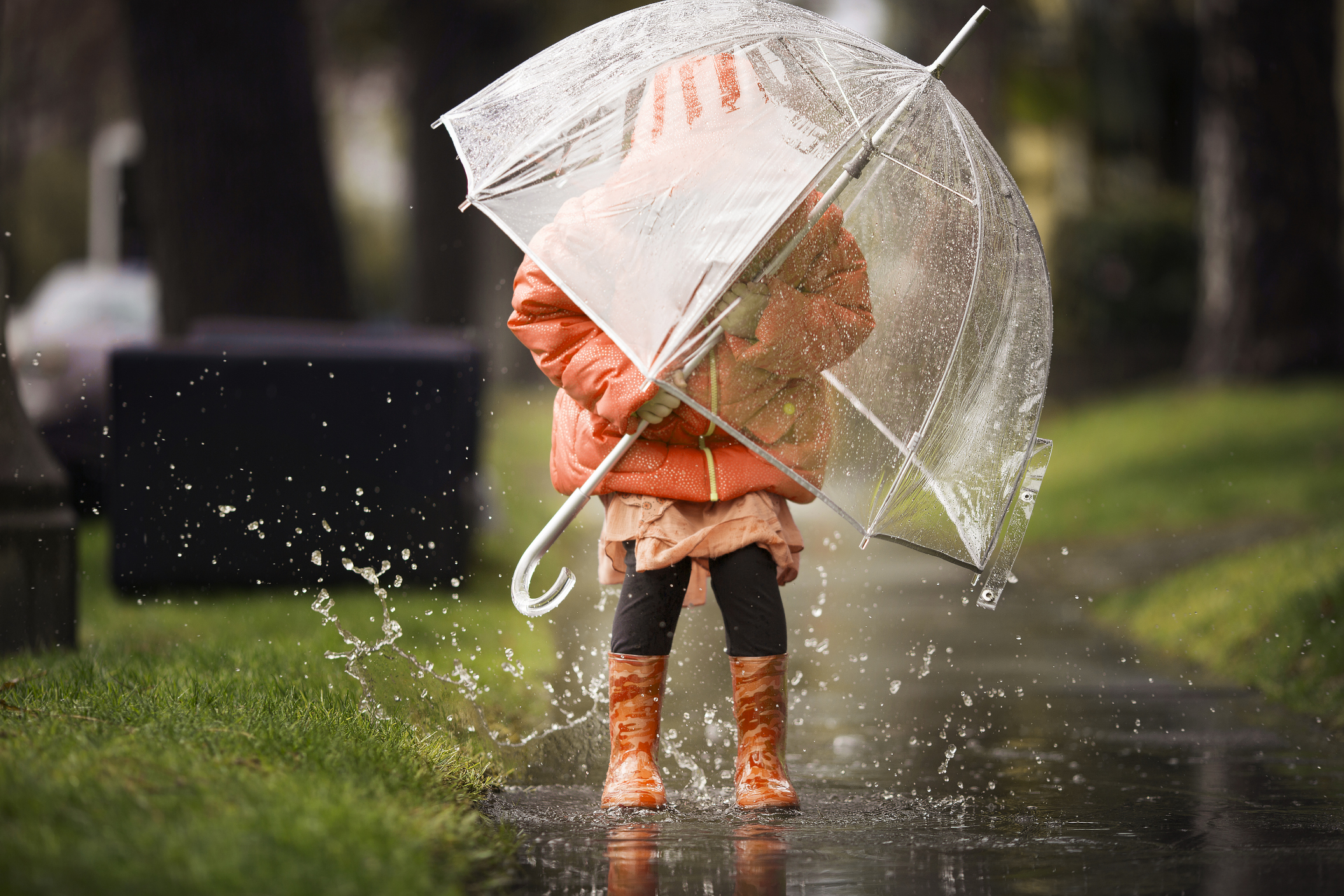 Junges Mädchen spielt im Regen