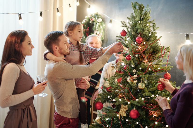 Familie steht um einen Weihnachtsbaum