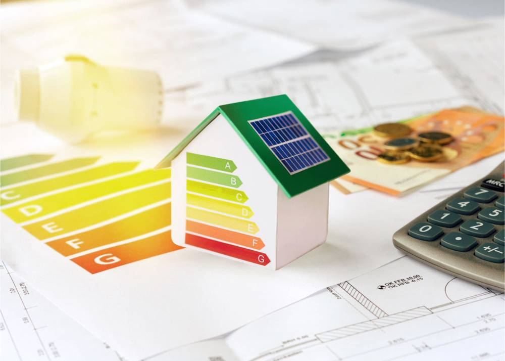 Kleines weißes Modellhaus mit grünem Dach zur Veranschaulichung der Energieeffizienz mittels Klassifizierungsdiagramm von A bis G