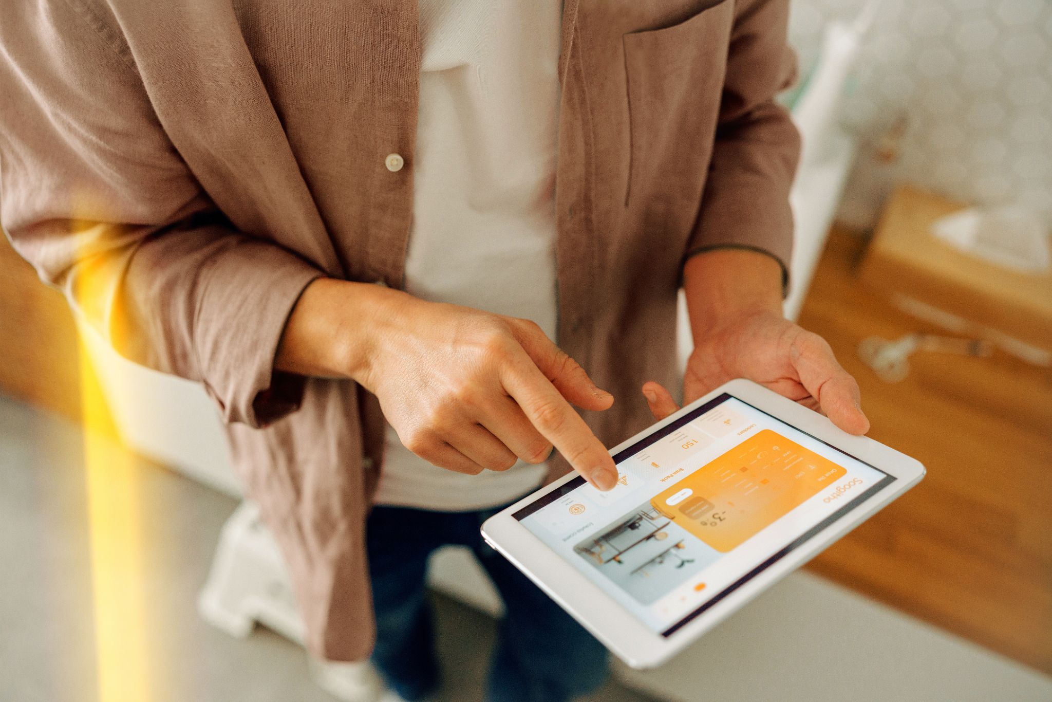 Ein Mann bedient mit seinem Tablet sein Home Energy Management System