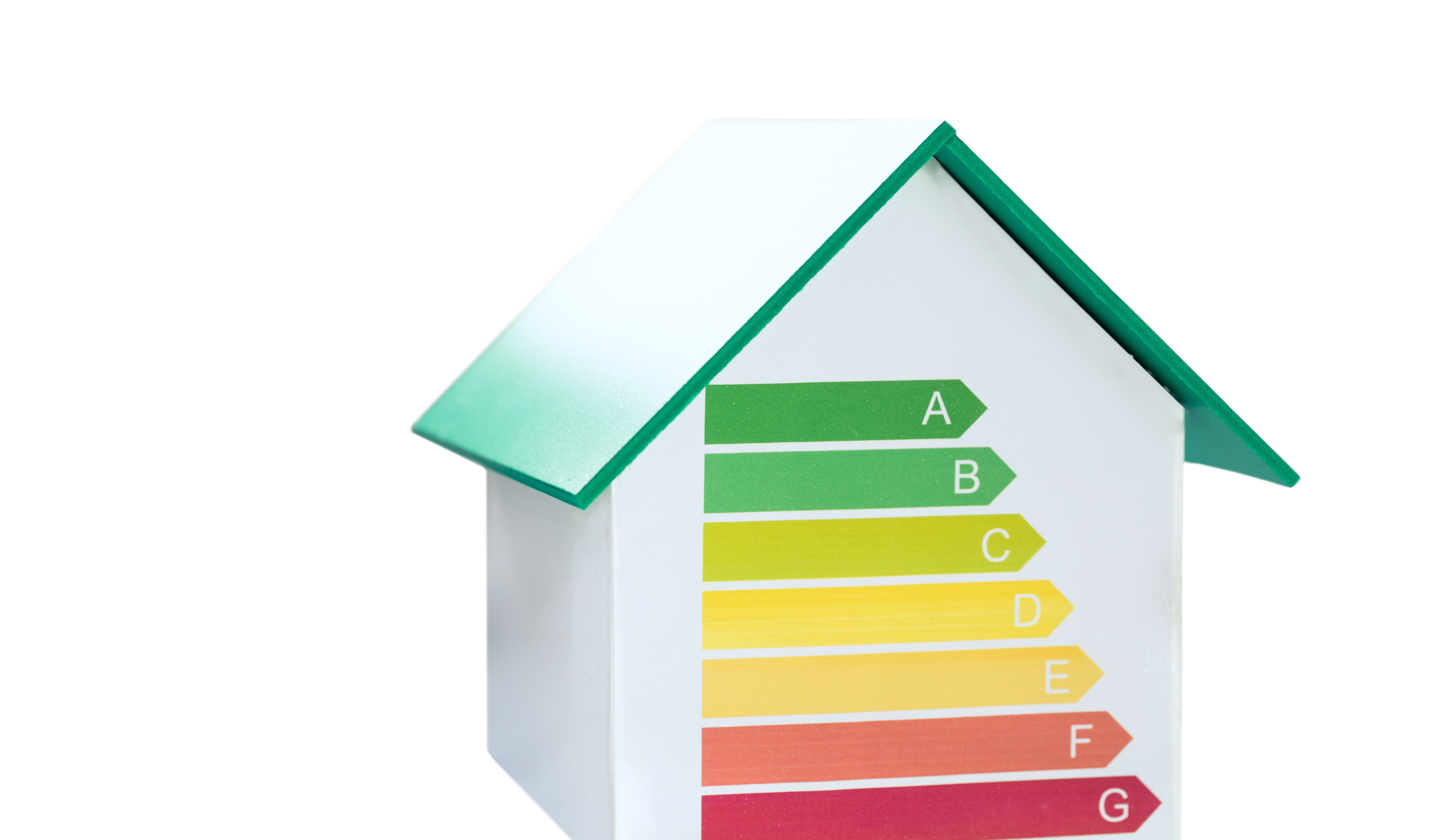 Kleines weißes Modellhaus mit grünem Dach zur Veranschaulichung der Energieeffizienz mittels Klassifizierungsdiagramm von A bis G