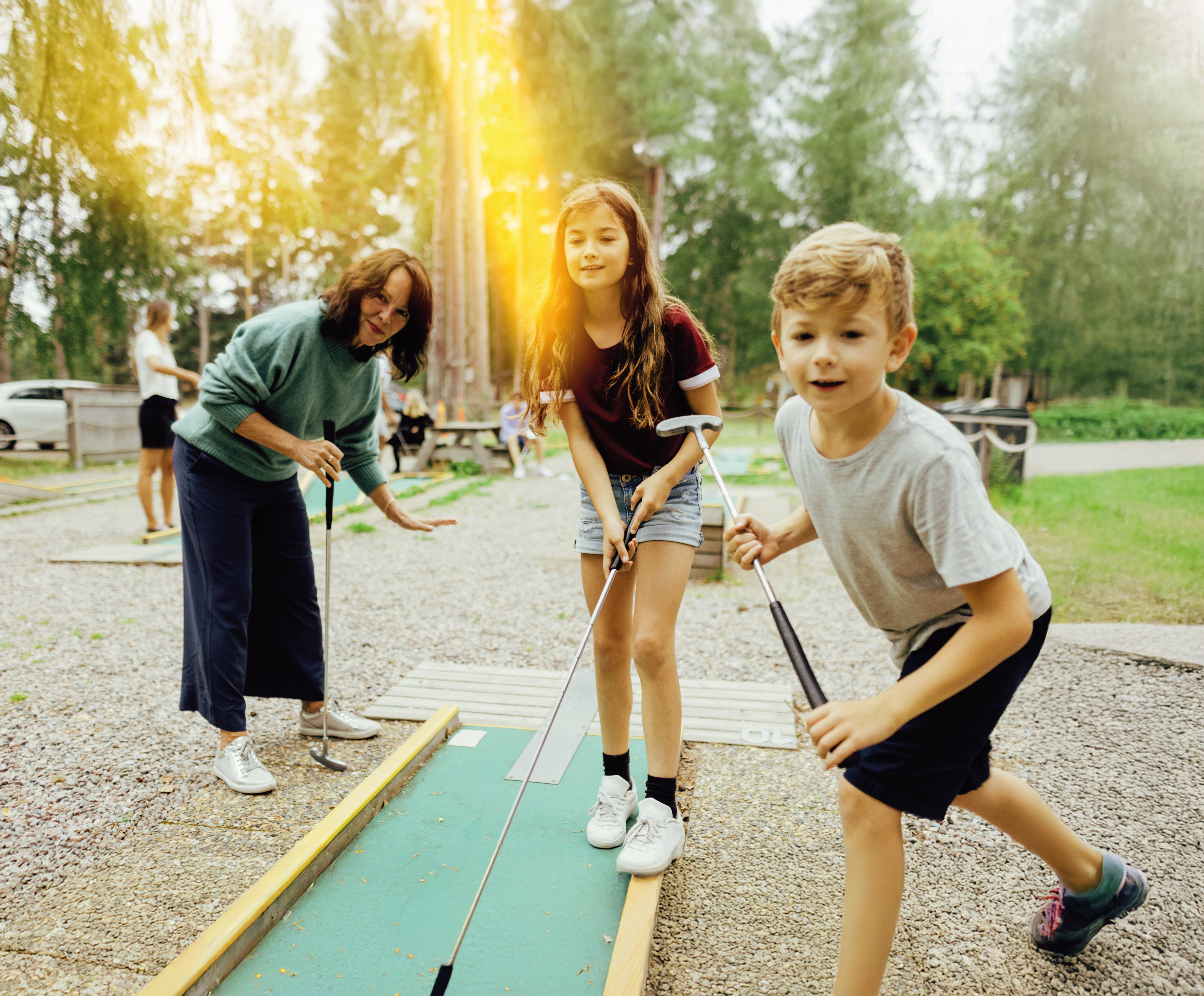 Kinder spielen Minigolf.