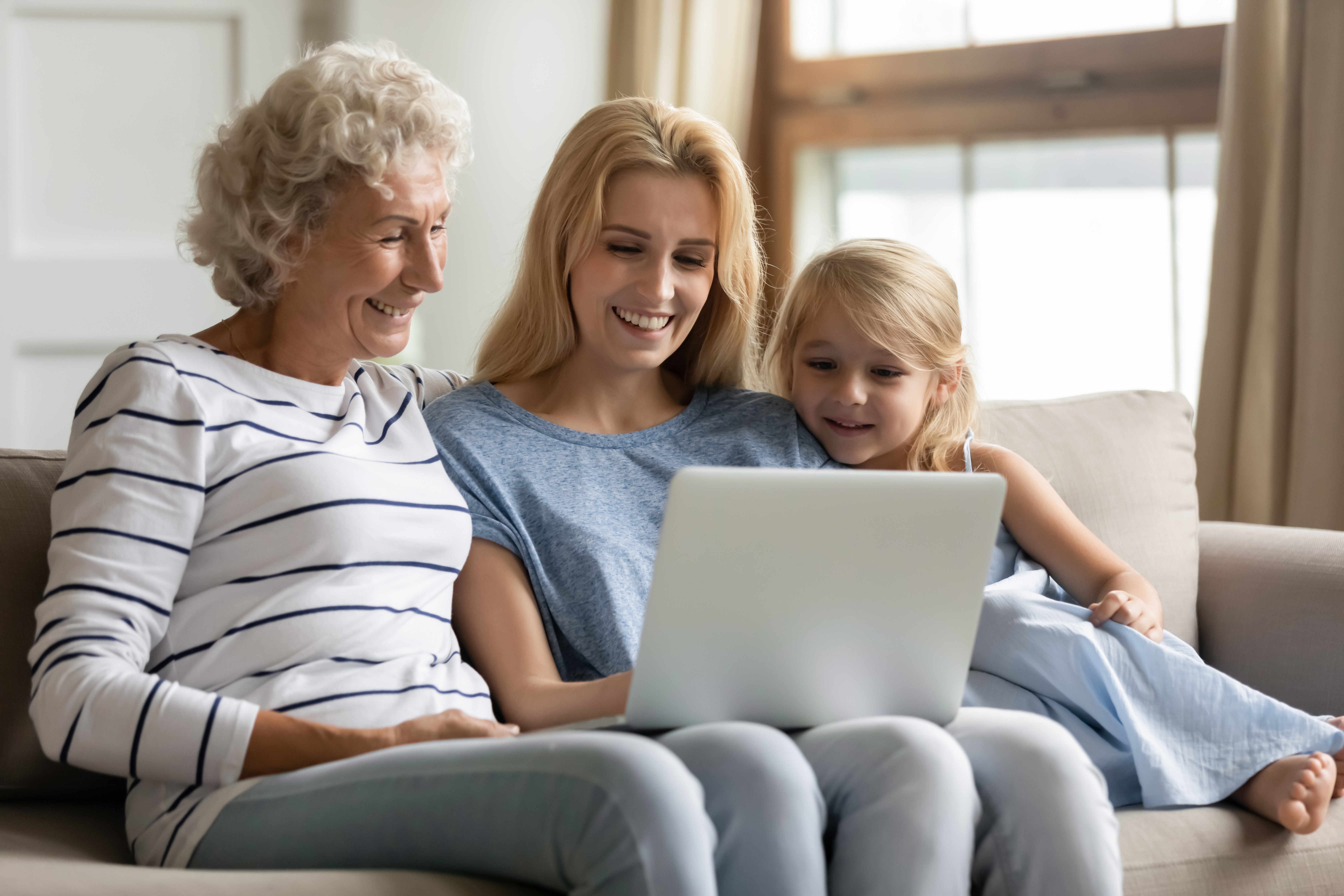 Oma, Mutter und Enkeling betrachten einen Laptop