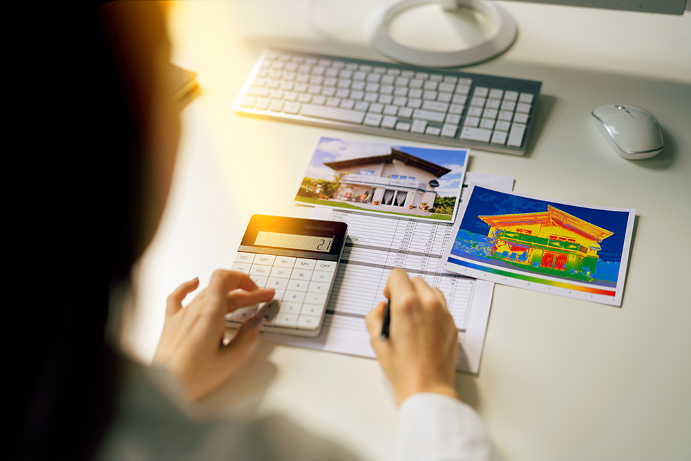 Wärmebildtechnik und Wärmethermografie - Frau kalkuliert Wärme-Kosten