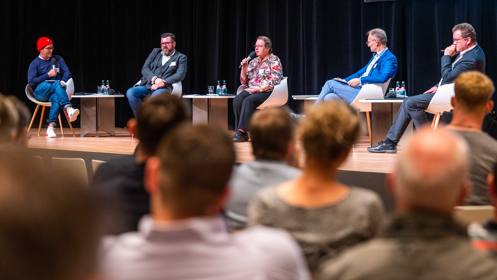 Vier Menschen bei einer Podiumsdiskussion