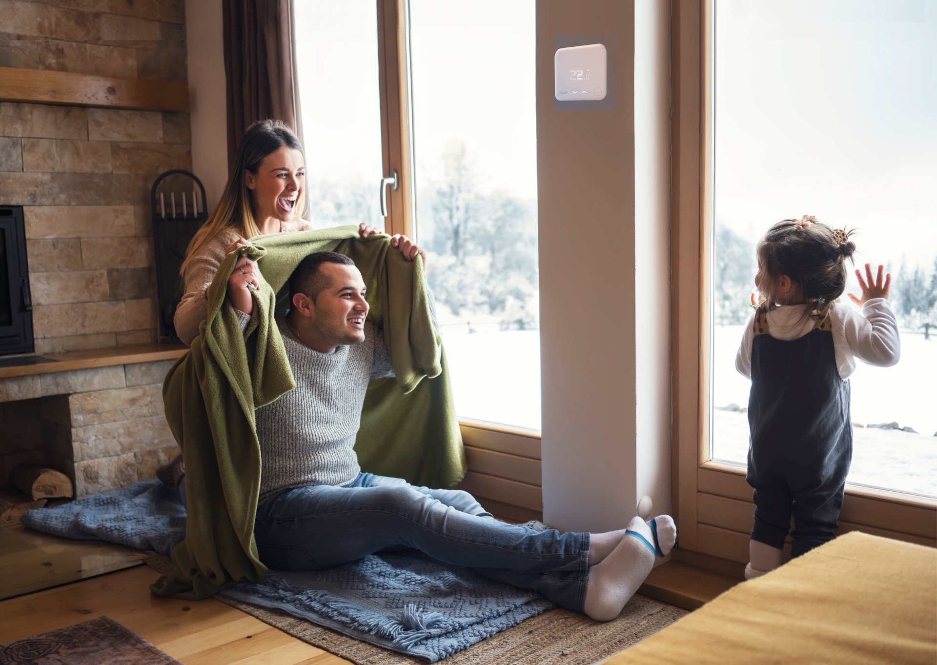 Familie sitzt auf Fußboden, während es draußen kalt ist