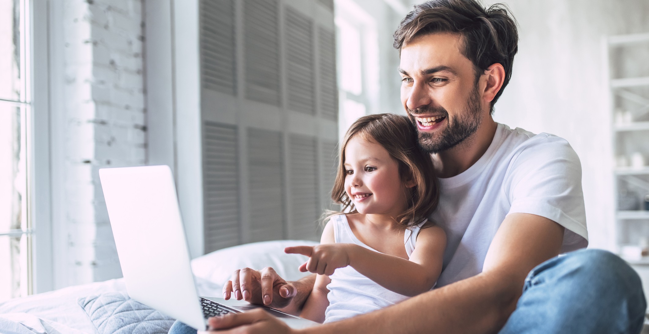 Vater und Tochter schauen auf einen Laptop