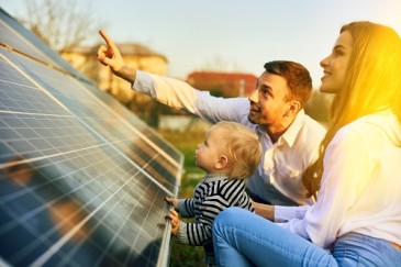 Glückliche Familie vor PV-Anlage