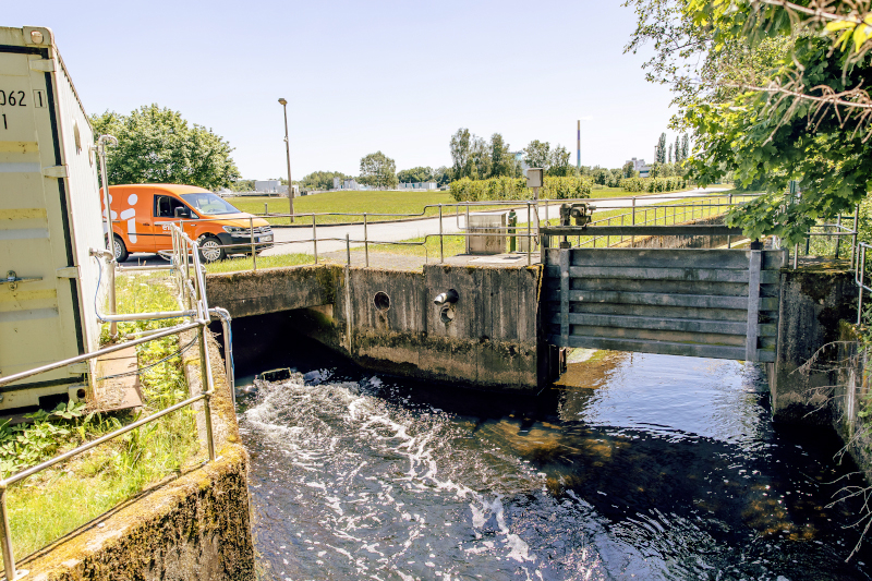 ein Kanal im Vordergrund ein eins Auto im Hintergrund