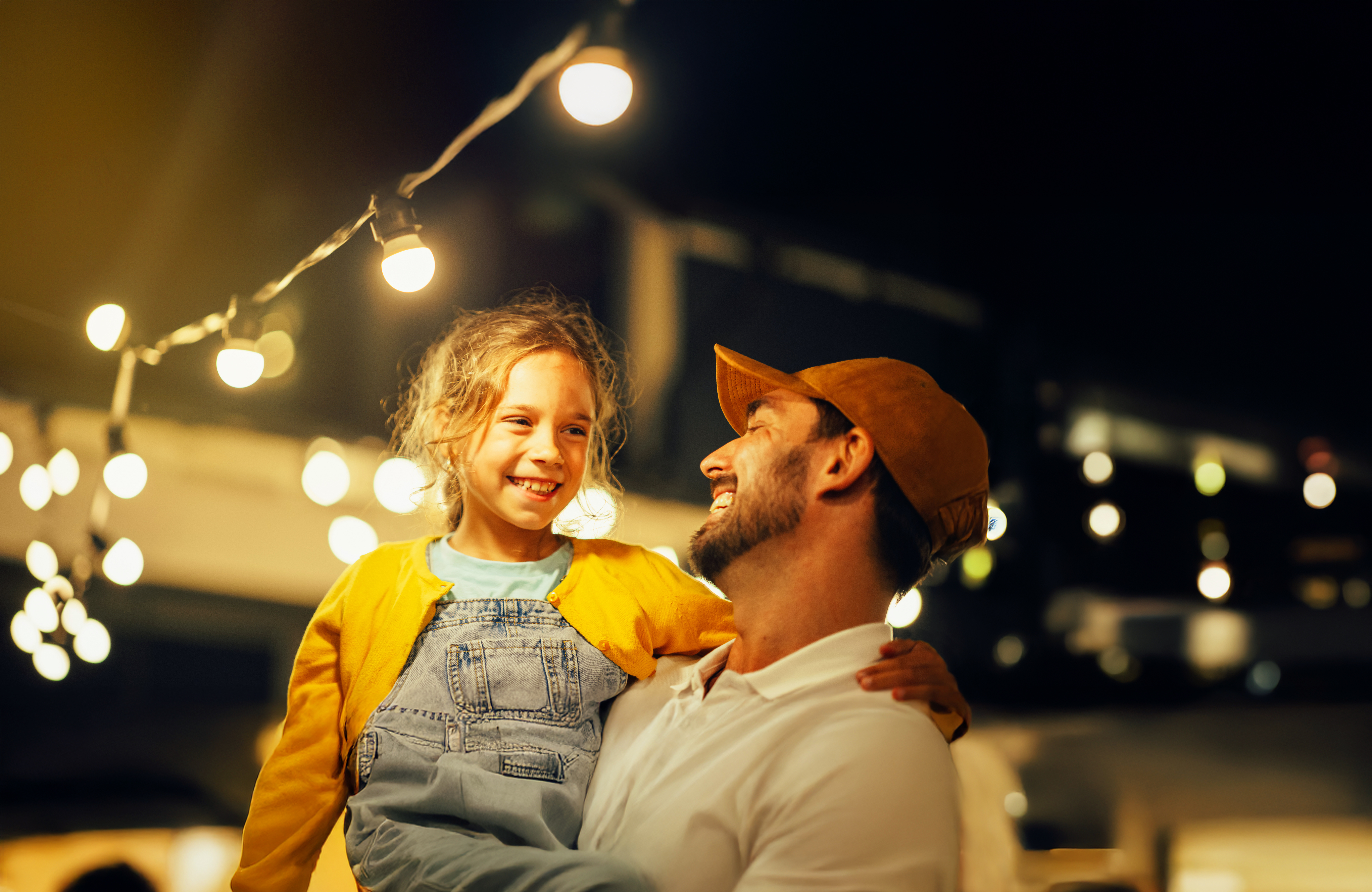 Vater sitzt mit Tochter im Zelt.