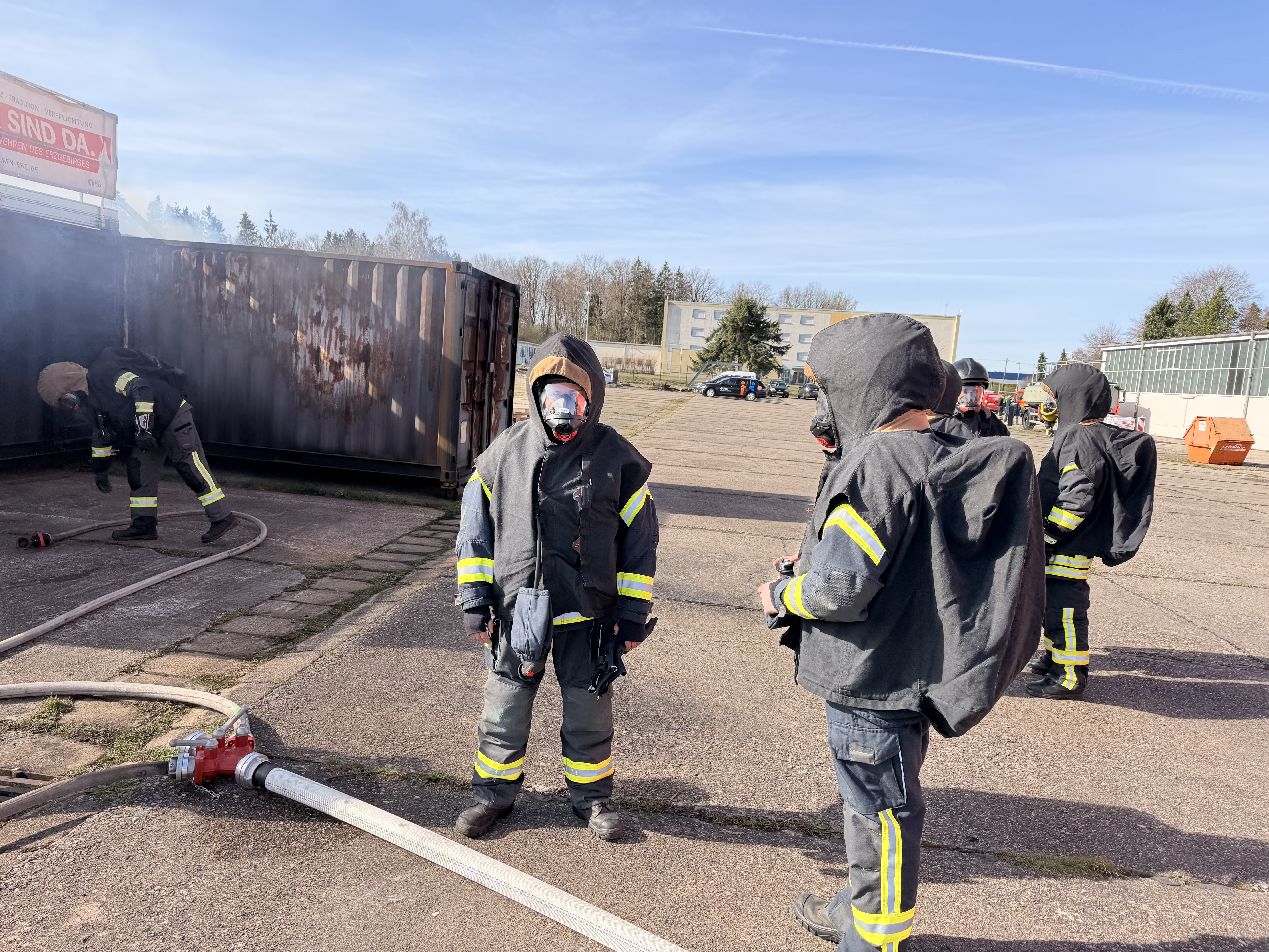 Feuwehrleute mit Atemmasken üben eine Brandlöschung. 