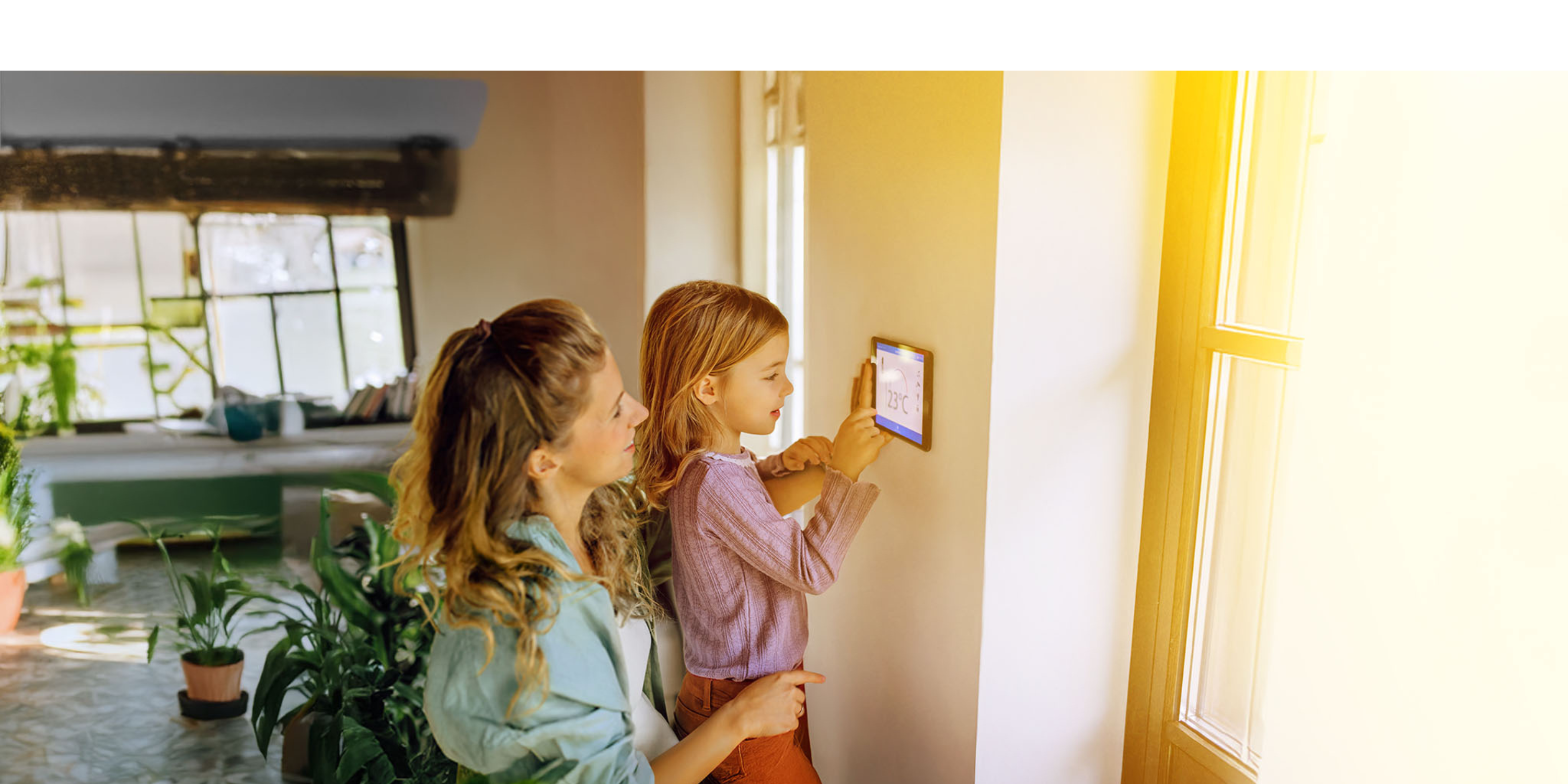Mama mit Kind regelt die smarte Heizung