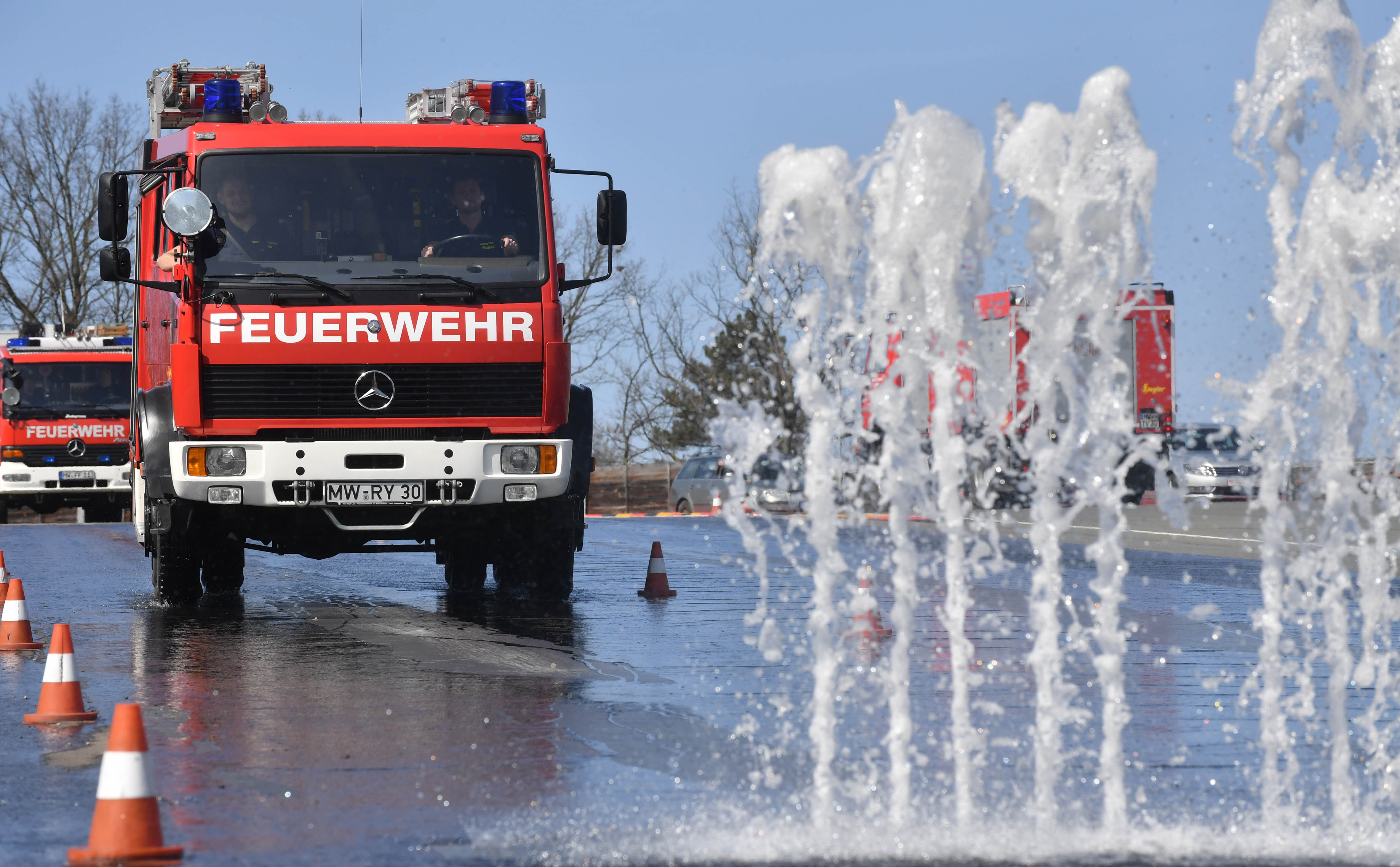 Loschfahrzeug der Feuerwehr beim Fahrsicherheitstraining um Wasserfontainen
