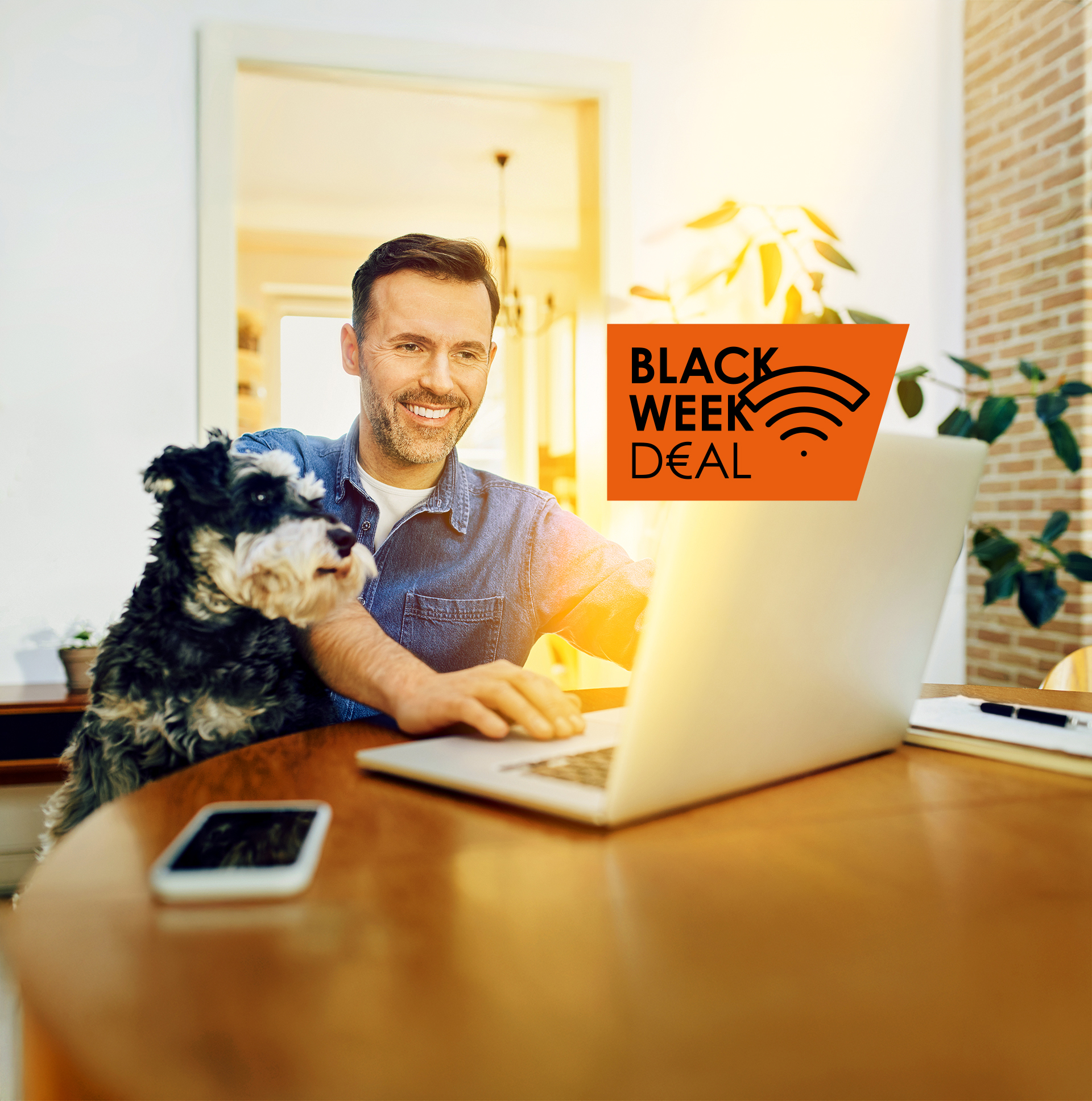 Mann mit Hund sitzt vorm Laptop