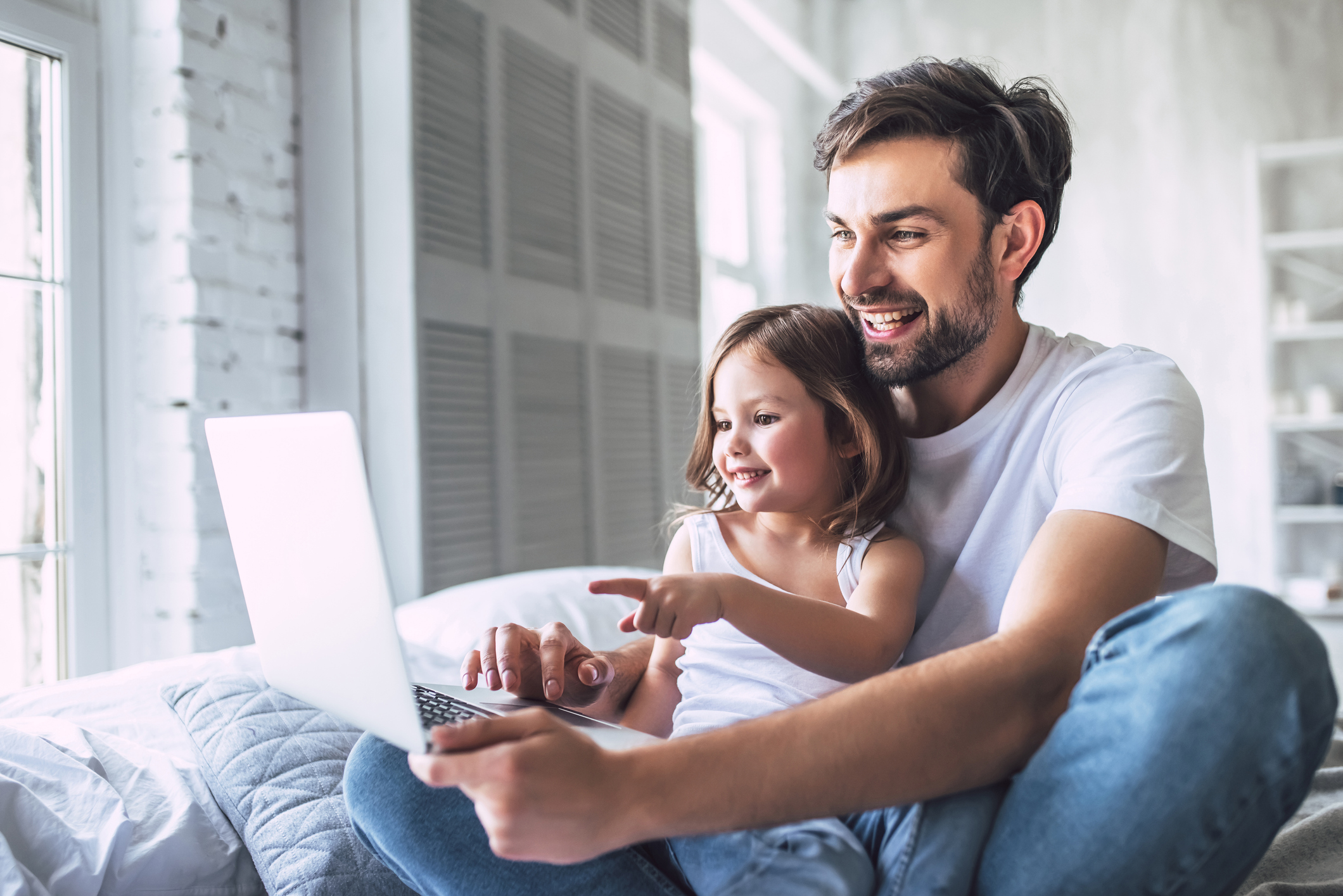 Vater und Tochter schauen auf einen Laptop