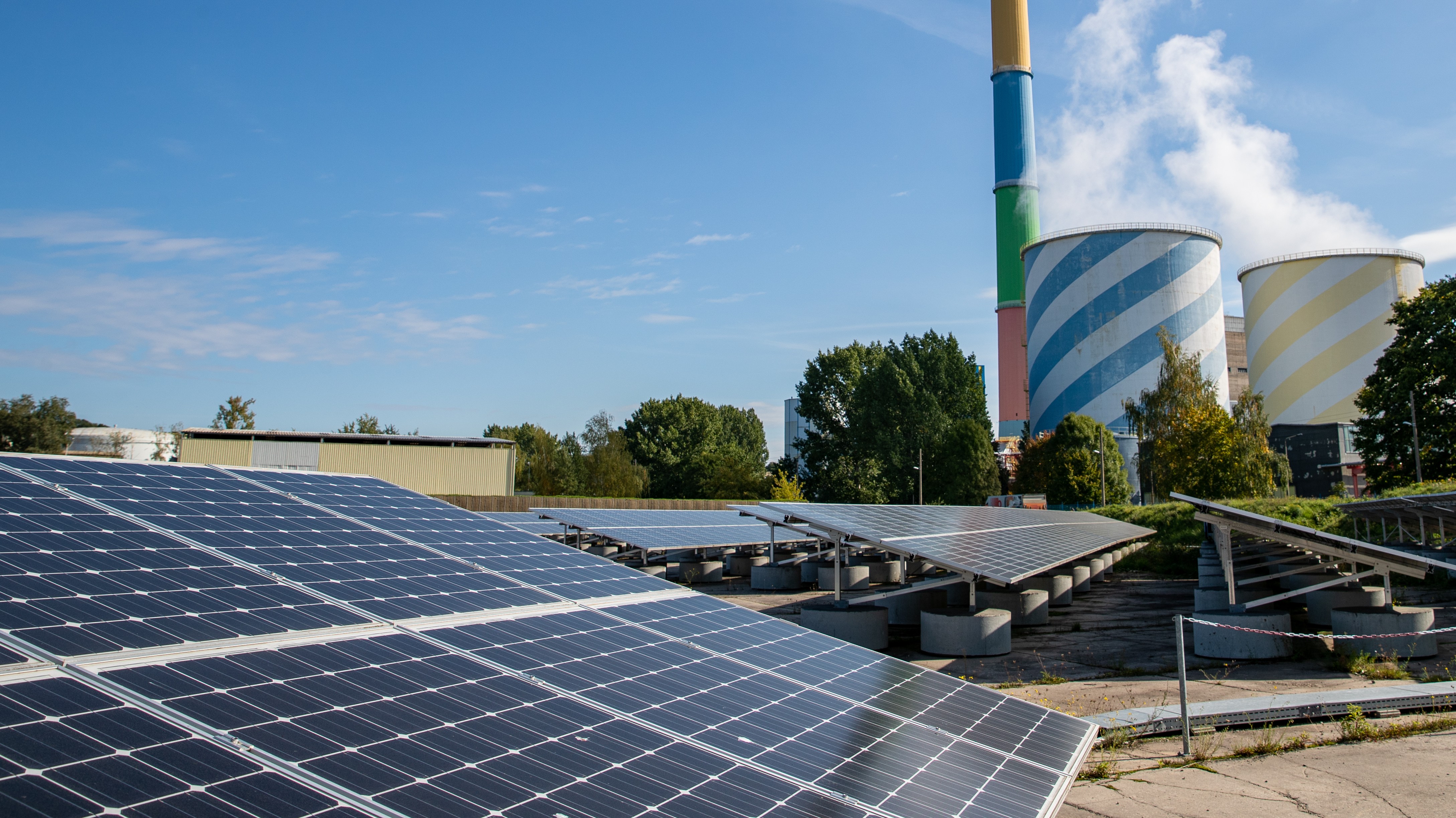 Photovoltaikanlagen vor Schornstein und Kühltürmen