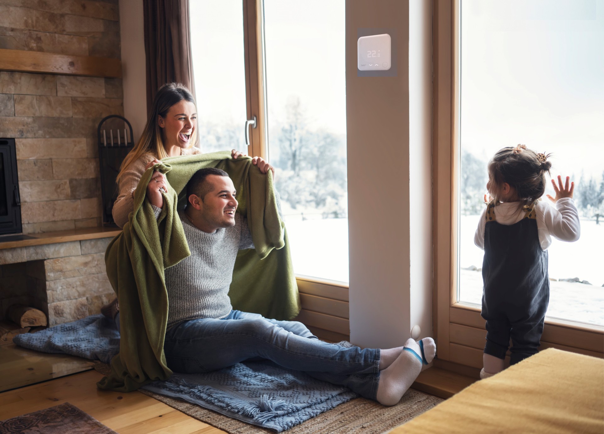 Familie sitzt auf Fußboden, während es draußen kalt ist