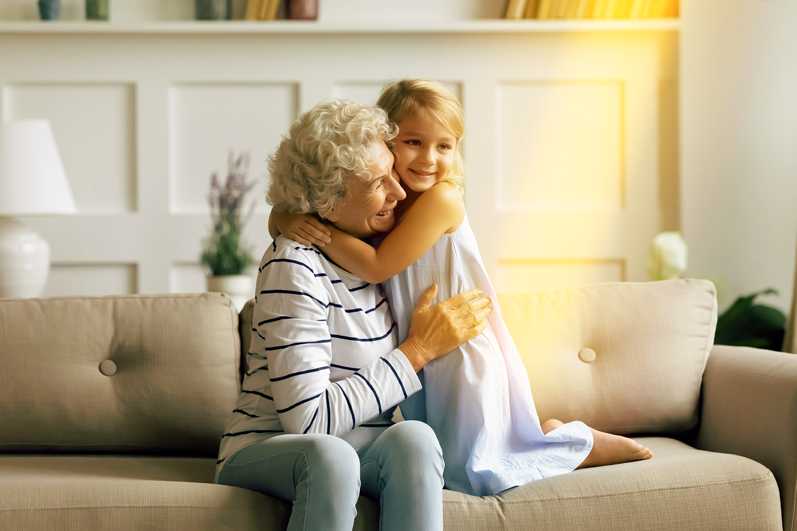 Oma spielt mit ihrer Enkelin auf der Couch