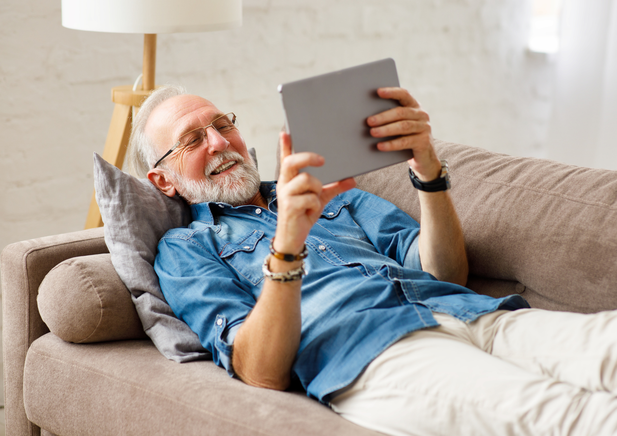 Älterer Mann schaut auf Tablet