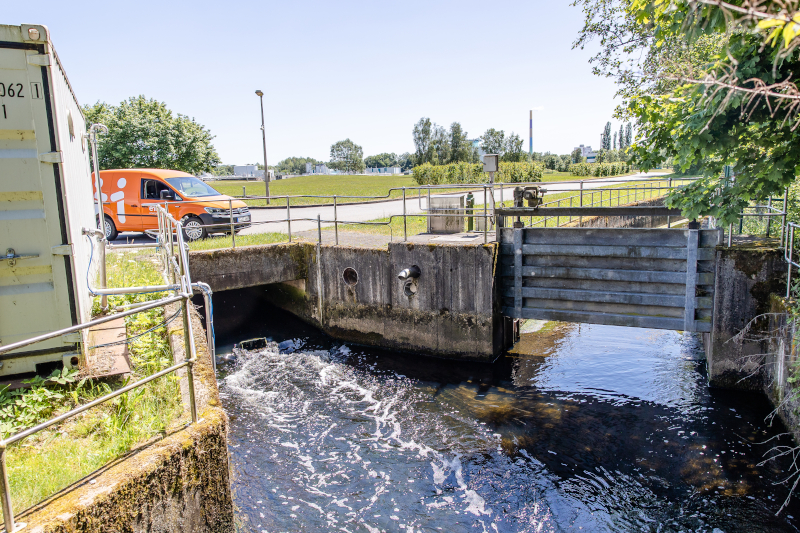 ein Kanal im Vordergrund ein eins Auto im Hintergrund