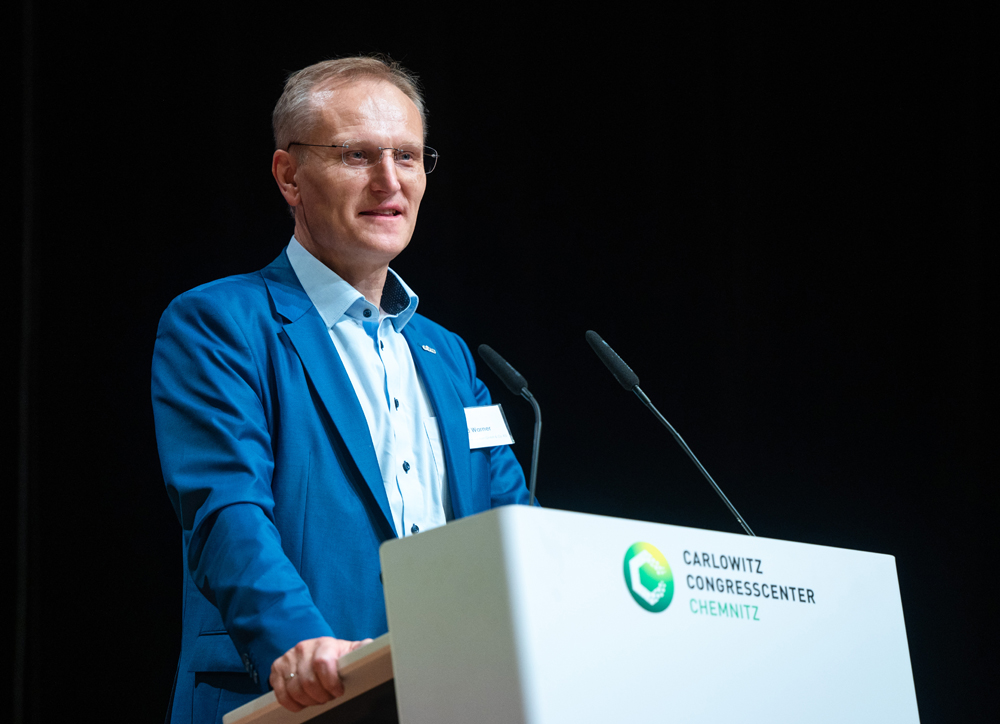 Roland Warner hält eine Rede am Rednerpult beim Energieforum 2022 und trägt einen blauen Anzug.