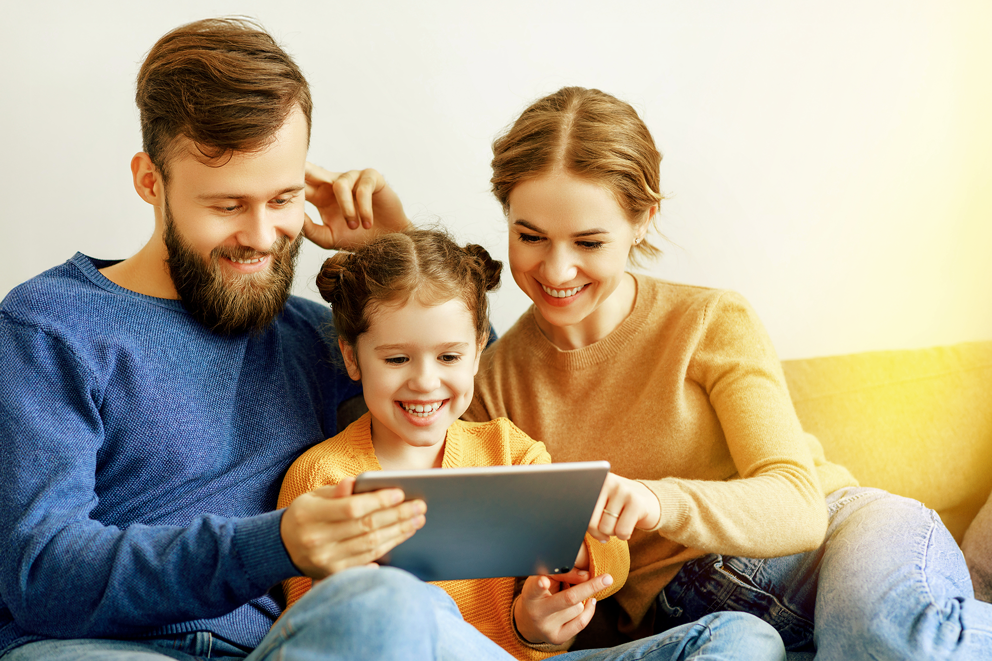 Eine Familie sitzt vorm Fernseher und isst Popcorn.