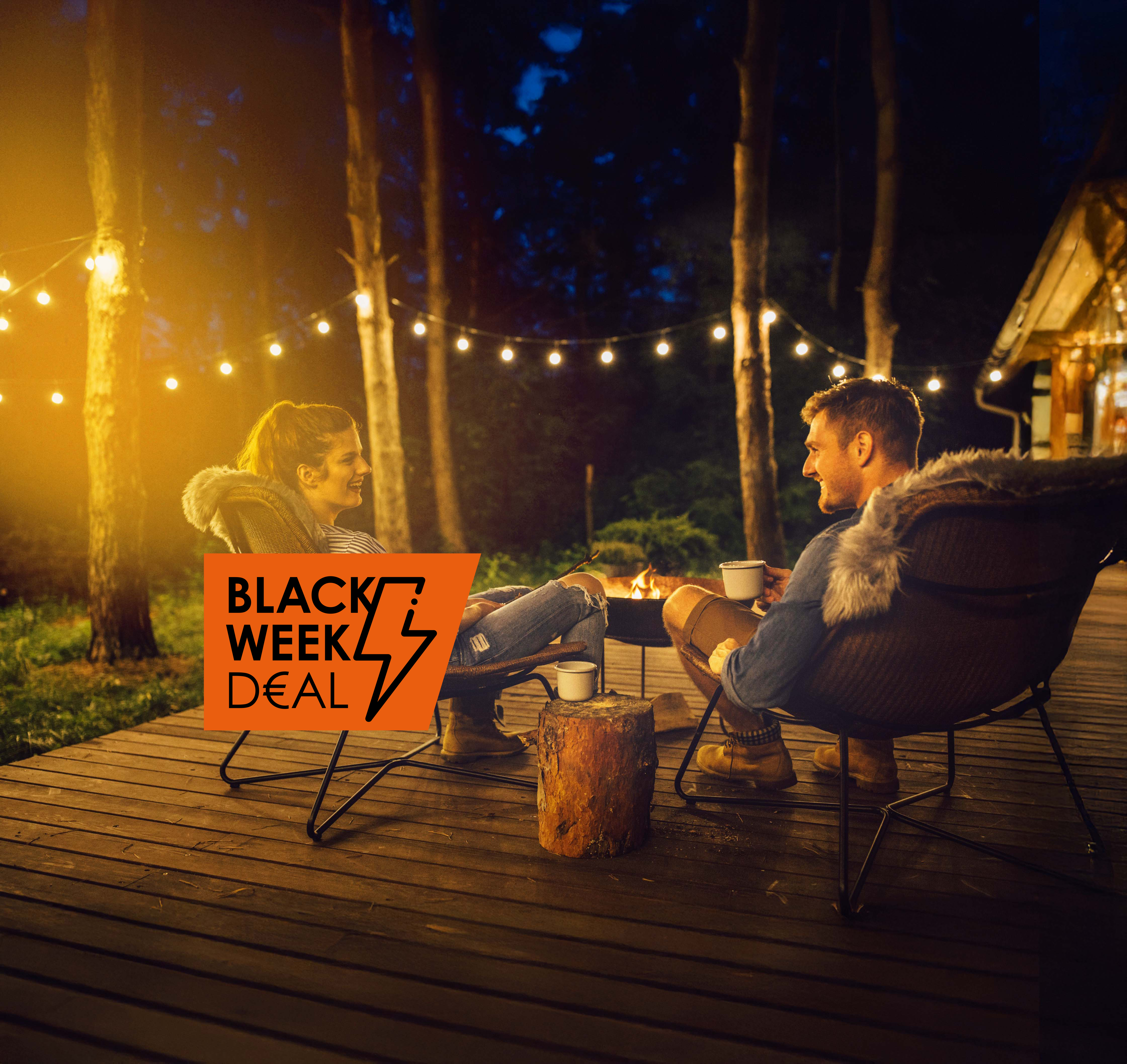 Paar sitzt draußen unter Lichterkette