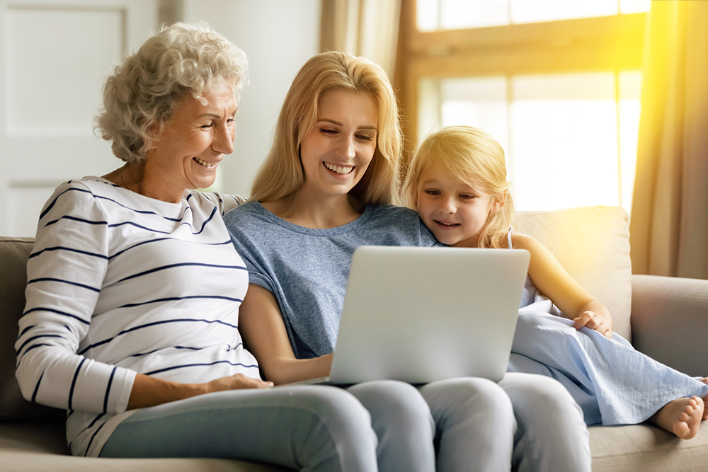 Oma, Mutter und Enkeling betrachten einen Laptop